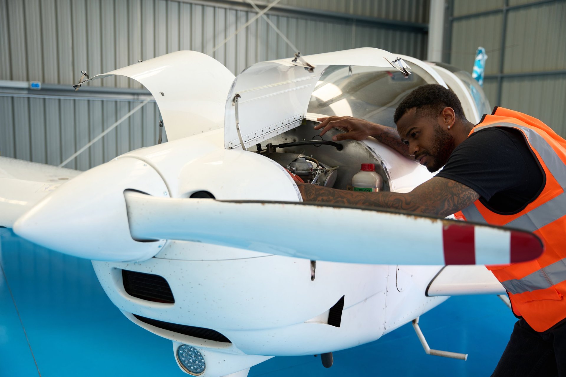 Aircraft mechanic inspecting airplane engine in hangar